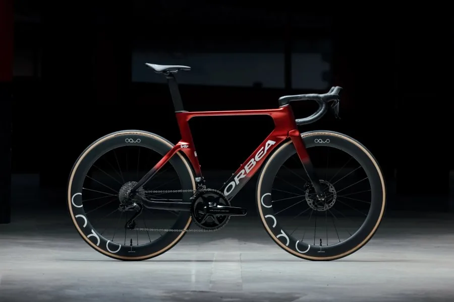 Röd Orbea landsvägscykel i studioljus